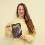 Casey Robinson is an up-and-coming local novelist, pictured here holding her first published work, “Legacy Rising.” Photo by Brittany Holbrooks