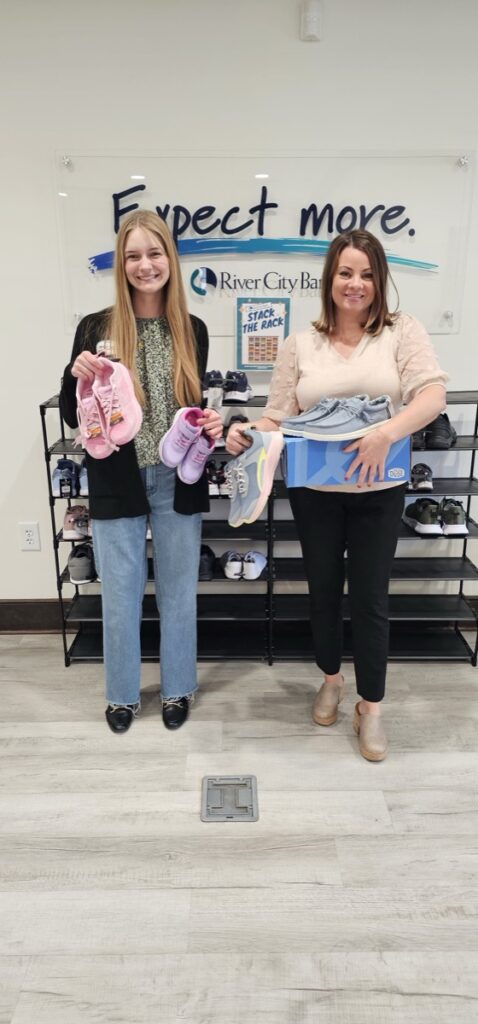 River City Universal Banker Alexis Moody and Human Resources Director Katie Mashburn promoting the Shoe Drive.