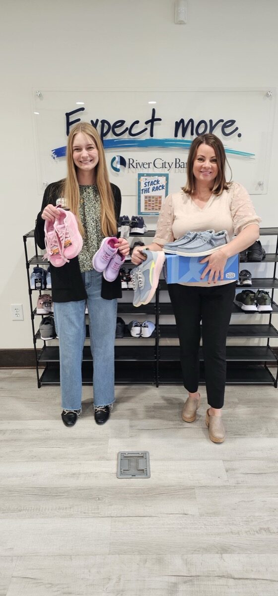 River City Universal Banker Alexis Moody and Human Resources Director Katie Mashburn promoting the Shoe Drive.
