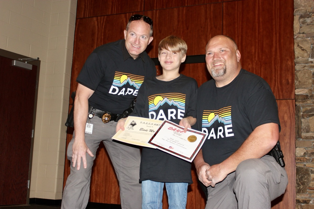 Elementary School student Blade Mull earned a special DARE Award in the recent graduation, posing here with School Police Chief Scott Deyton and Assistant Chief Chris Jackson. Photo by Brittany Holbrooks