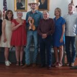 (L-R) Historical Society Member Mickey Cummings with the late Randall Collins’ daughter Jamie Shook, daughter Sherri Jones, granddaughter Finley Collins, grandson Easton Collins, brother F.C. Collins, daughter-in-law Shawna Collins and son Benny Collins, plus Historical Society President Mike Cook. Photo by Brittany Holbrooks