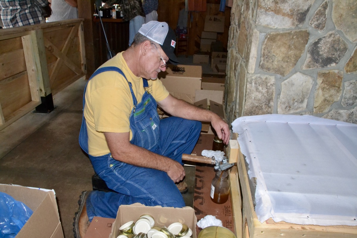 Union County Manager Tony Hughes bottled up freshly made sorghum syrup over the weekend, showcasing the joint effort of many volunteers to keep the festival tradition alive in 2025 and beyond. Photo by Brittany Holbrooks