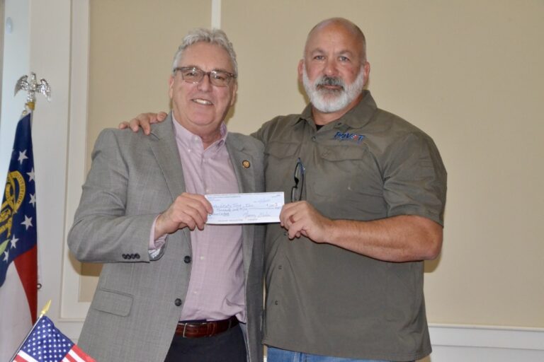 Rotary Club of Union County President Chuck Henz presenting a donation to retired Air Force Command Chief Master Sgt. William Markham for his nonprofit specializing in helping veterans secure the benefits they deserve. Photo by Brittany Holbrooks
