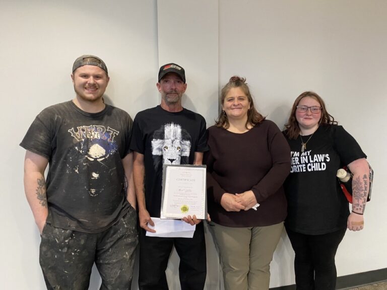 Mark Kelley, pictured here holding a certificate of completion, was proud to have his son Christian, wife Rebecca and daughter-in-law Abby attend his North Enotah Drug Court Program graduation this month. Photo by Samantha Laratta