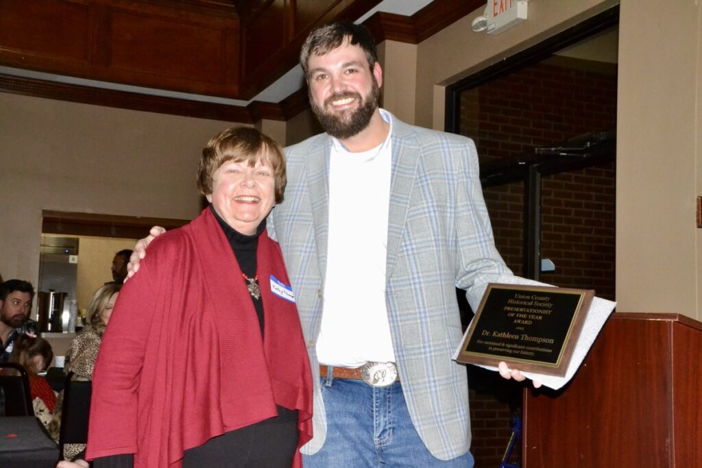 Dr. Kathleen Thompson receiving the “Preservationist of the Year Award” from Historical Society President Mike Cook. Thompson nominated the society for a major state award, which it won. Photo by Brittany Holbrooks